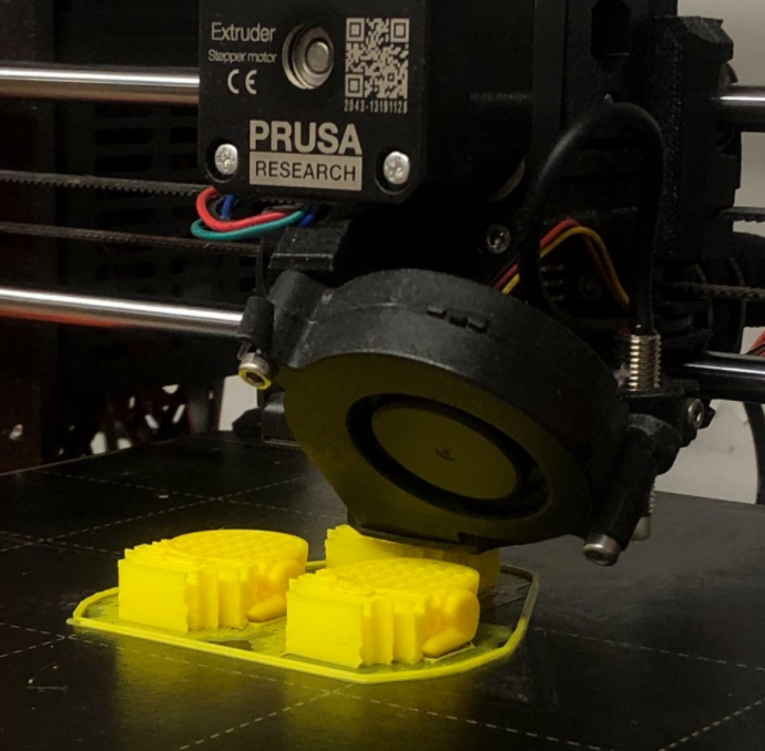 The half-finished bunnies undergoing the printing process with a printing tip on top of it.