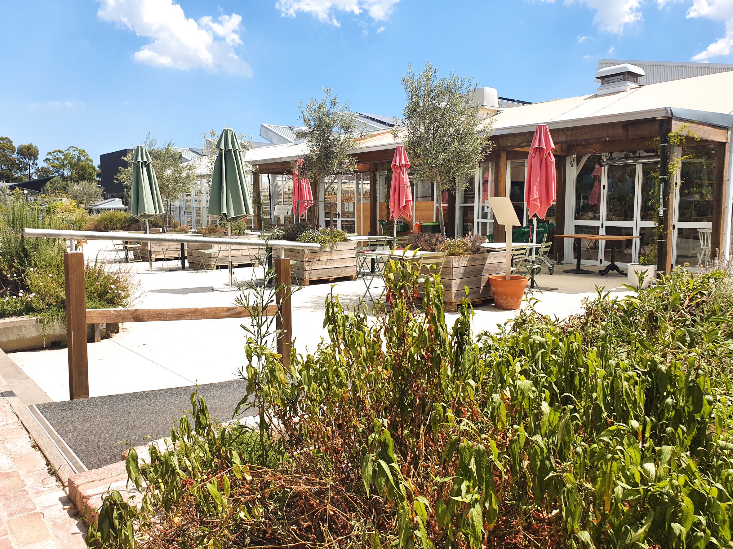 Outdoor area featuring glasshouse and outdoor dining on rooftop garden