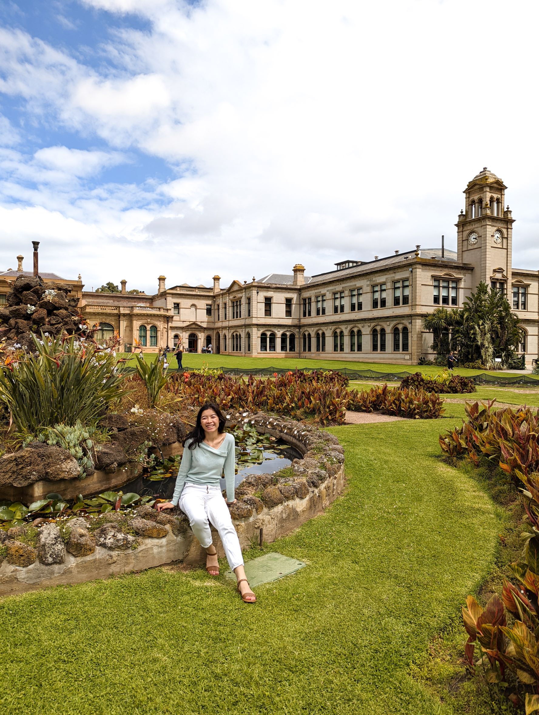 Asian girl sitting in front fountain at Werribee Mansion 