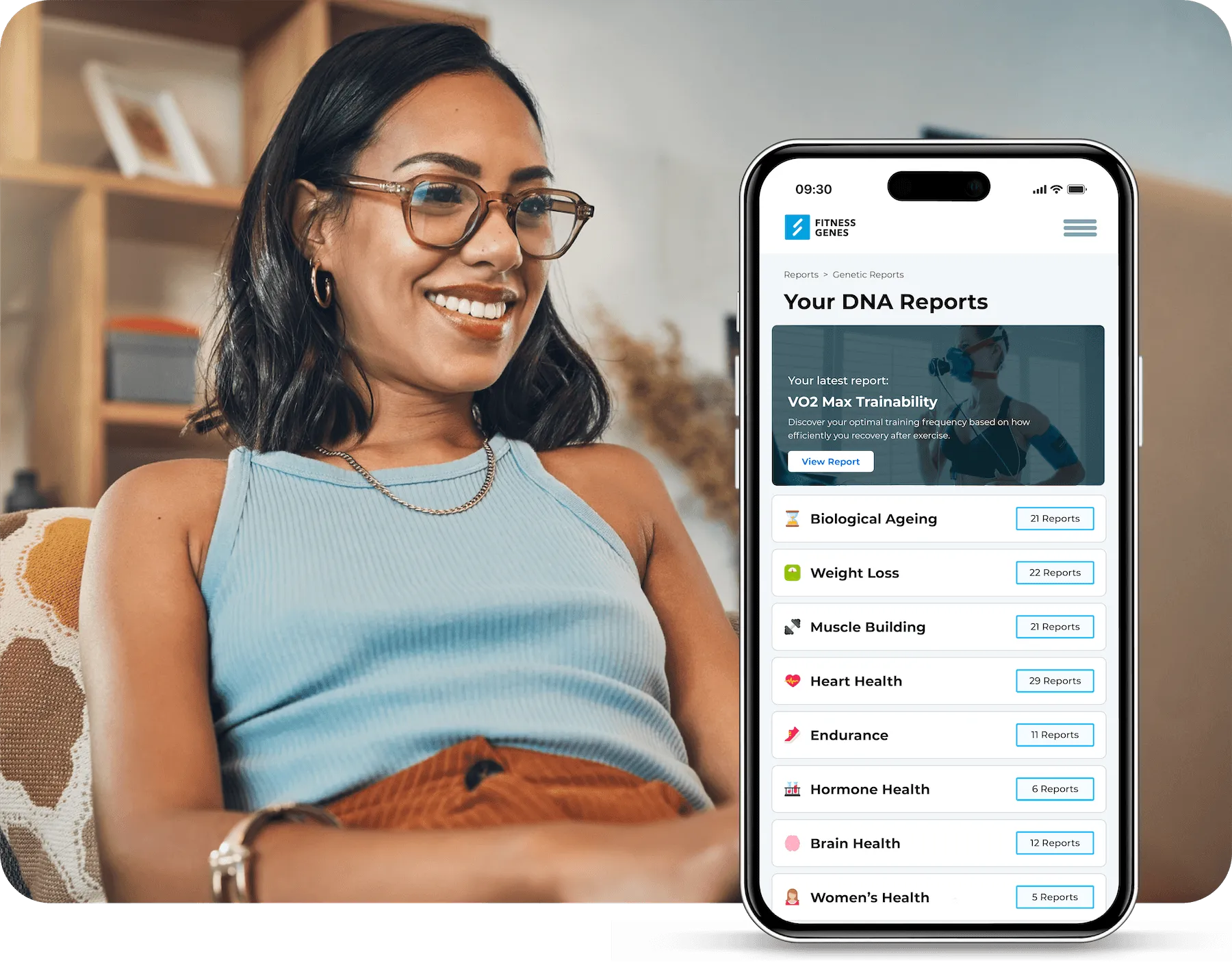 Person smiling while viewing FitnessGenes DNA reports and personalized health insights on a smartphone at home.