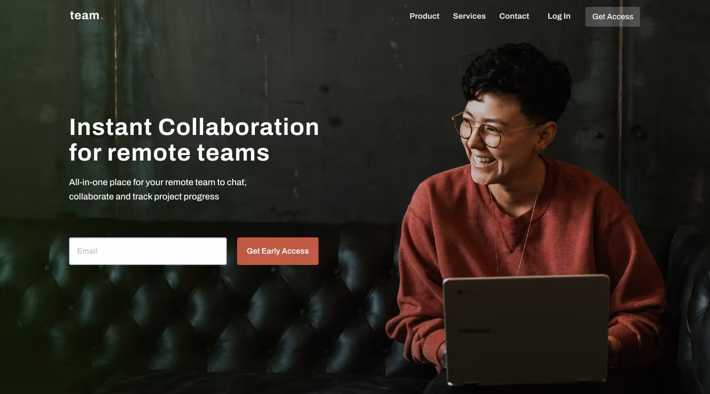 A human being in green cafe, smiling and laughing while working on a project on their laptop. 