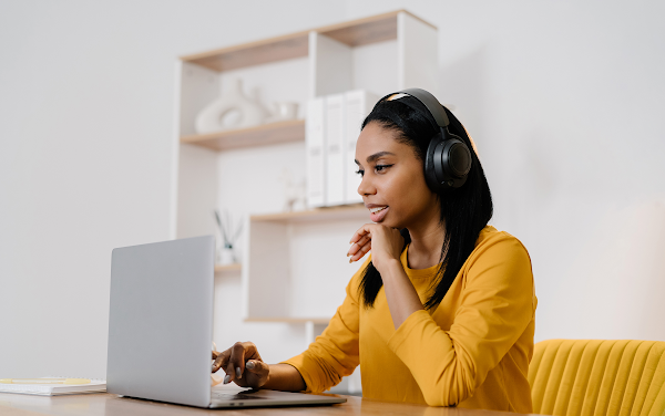 Woman with a headset at a laptop reaching out to influencers