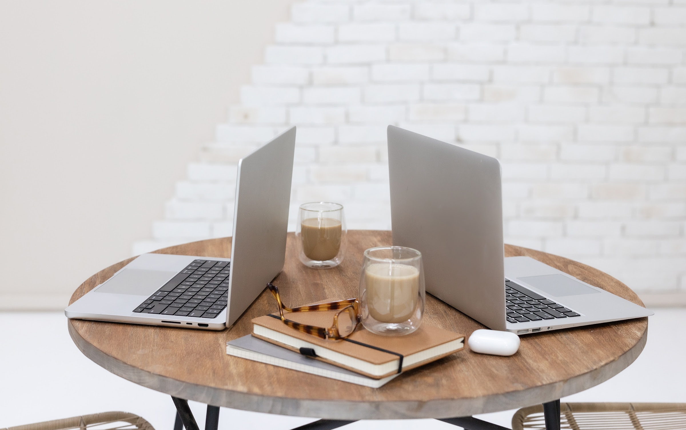 Two laptops on a round table set up for content planning and repurposing