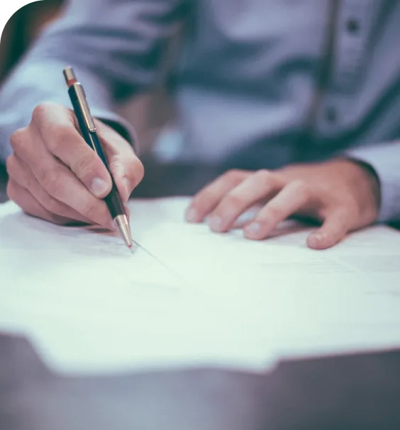 Hand unterschreibt ein Schriftstück, Sinnbild für das Vertragsrecht