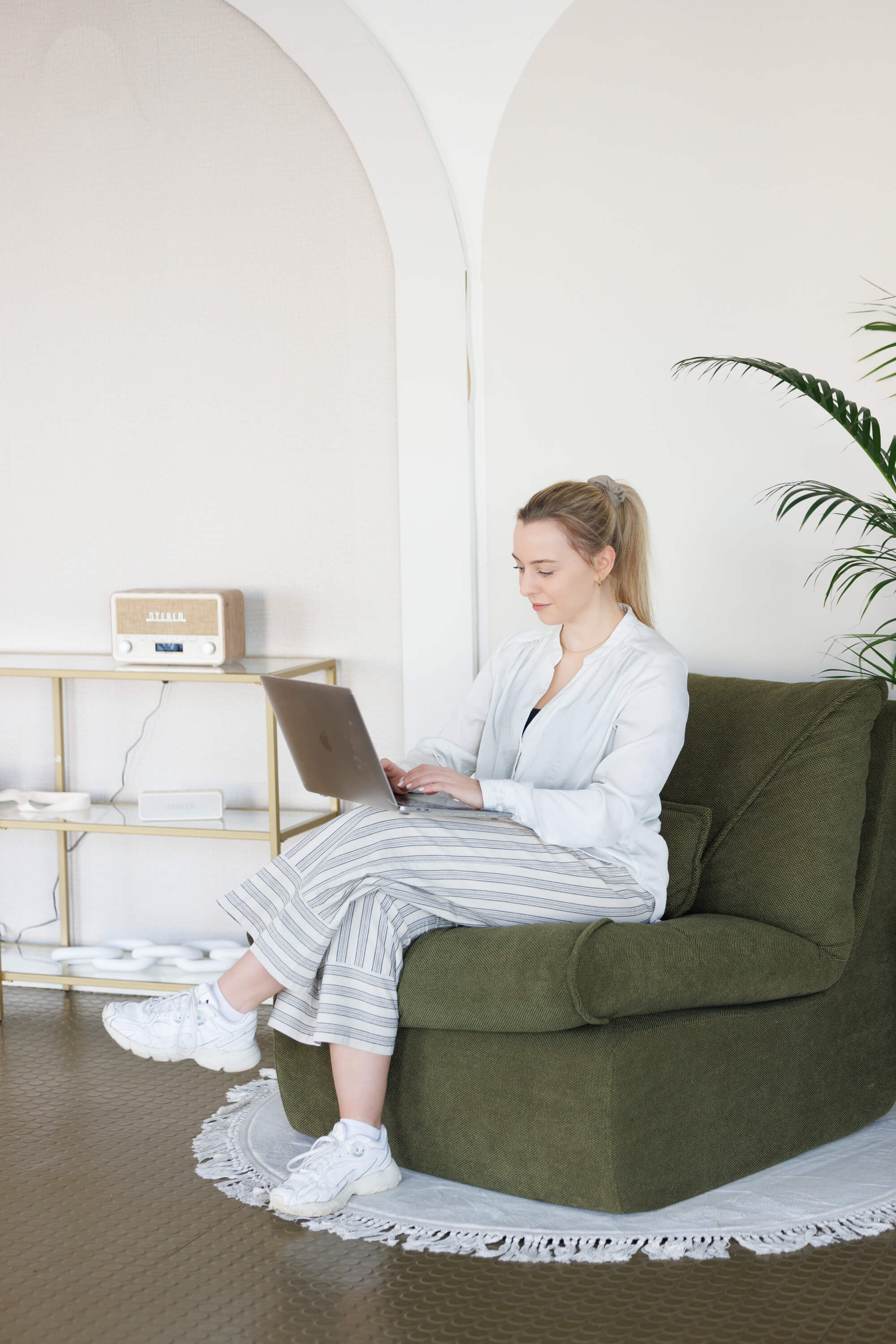 Tina Hörholdt arbeitet am Laptop in einem grünen Sessel