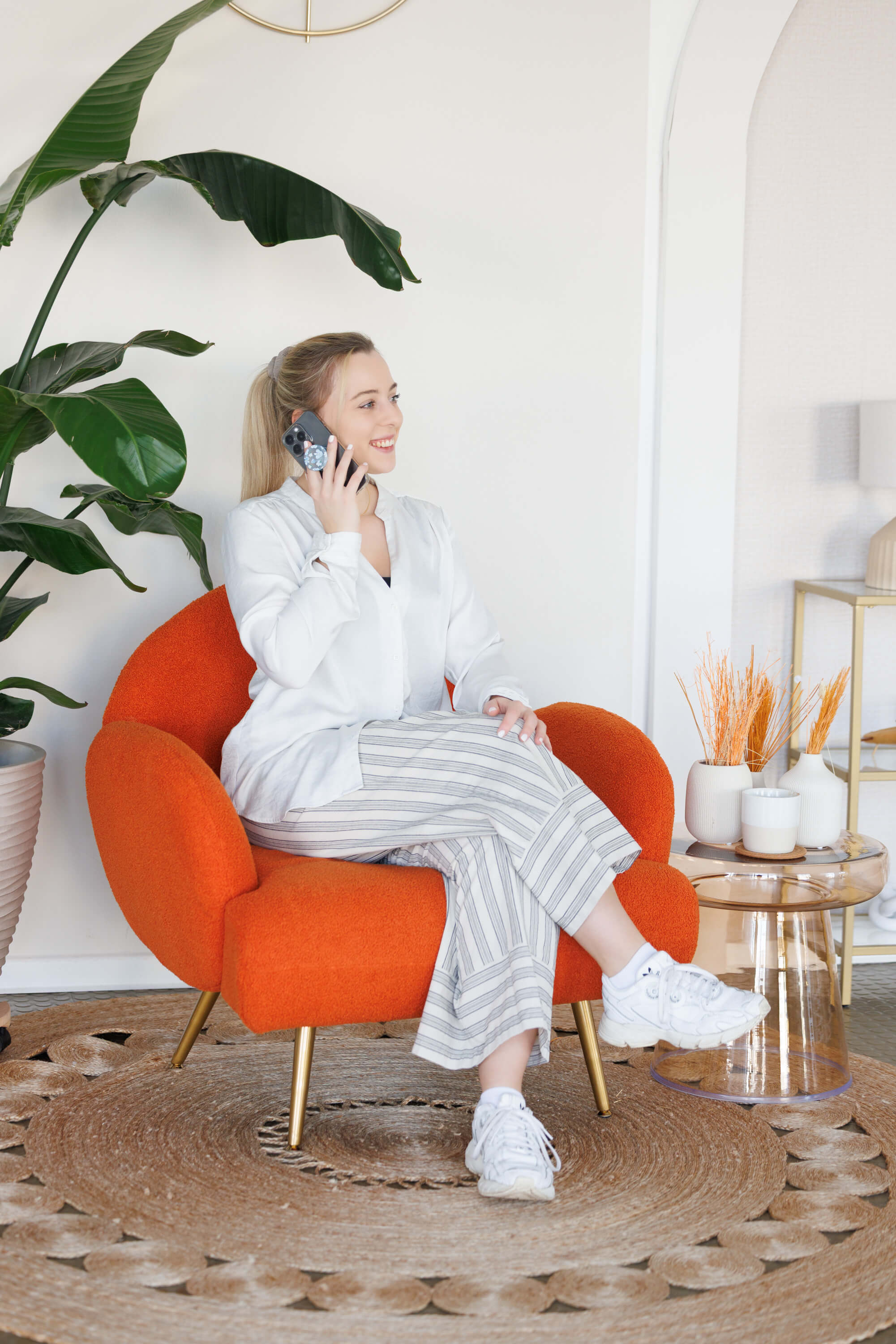 Tina Hörholdt on the phone in an orange armchair