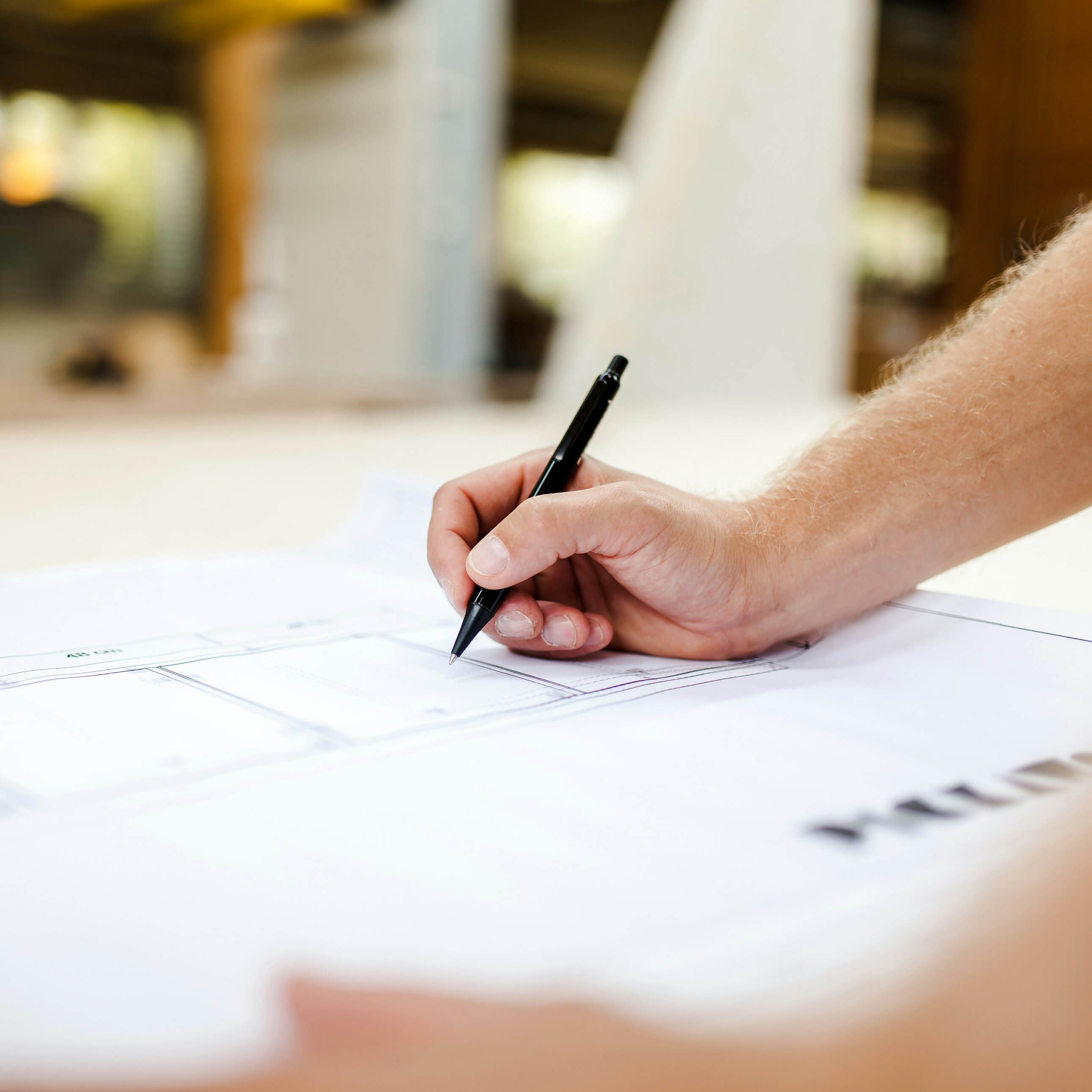 Hand with a pen drawing on a technical plan