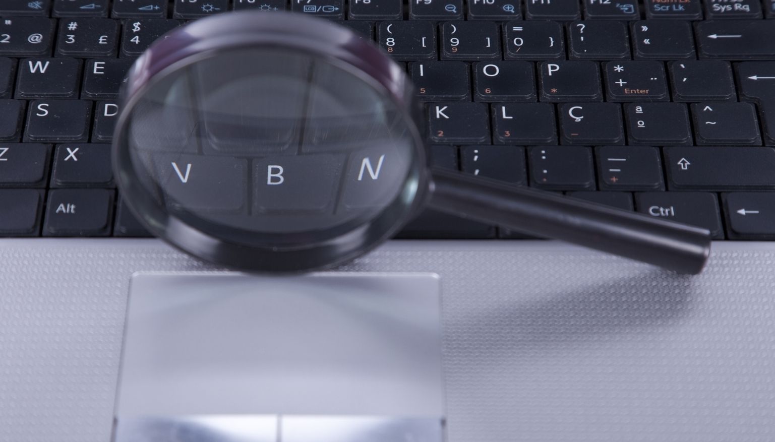 Magnifying glass over a laptop keyboard