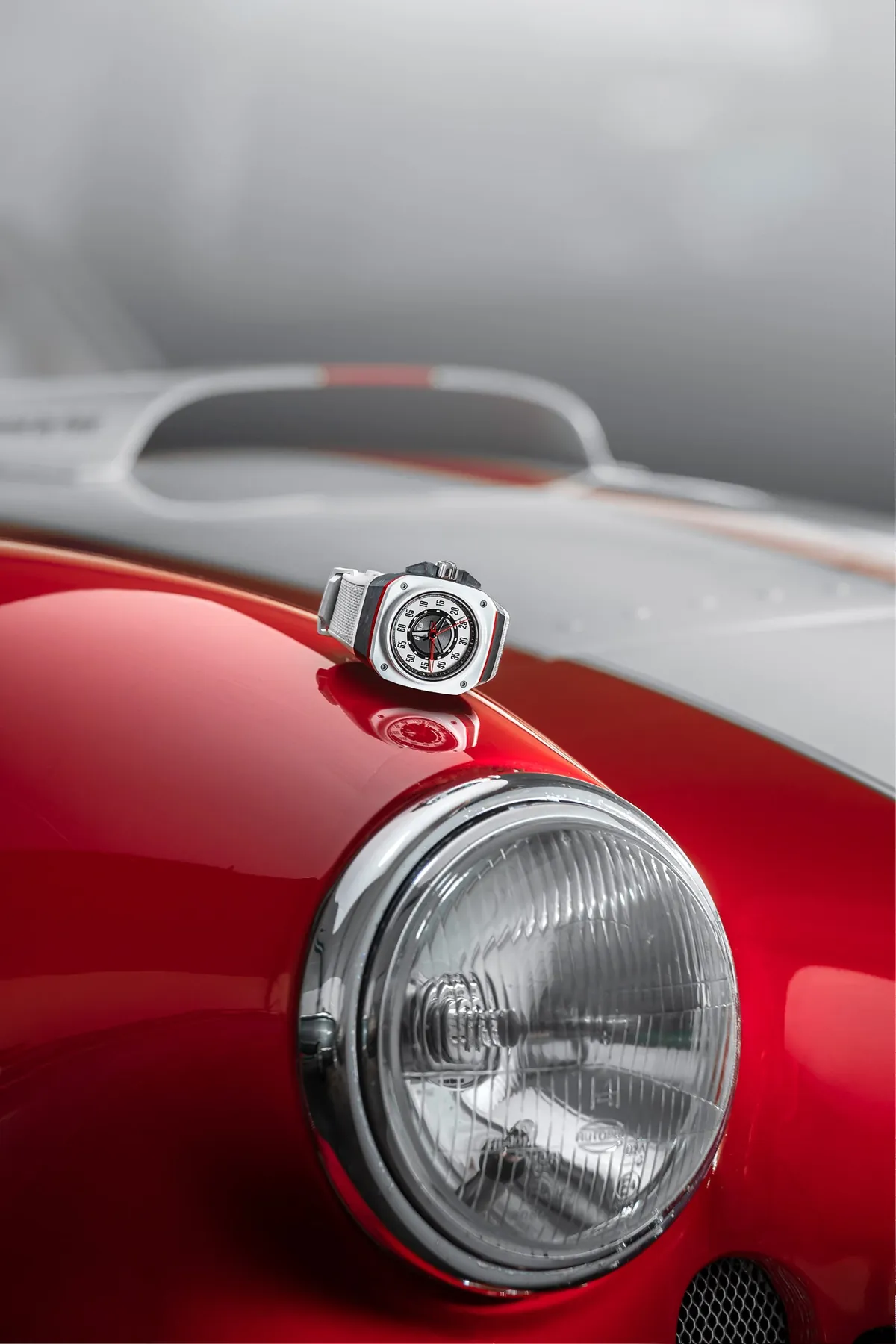 Gorilla watch resting on the headlight of a red classic car
