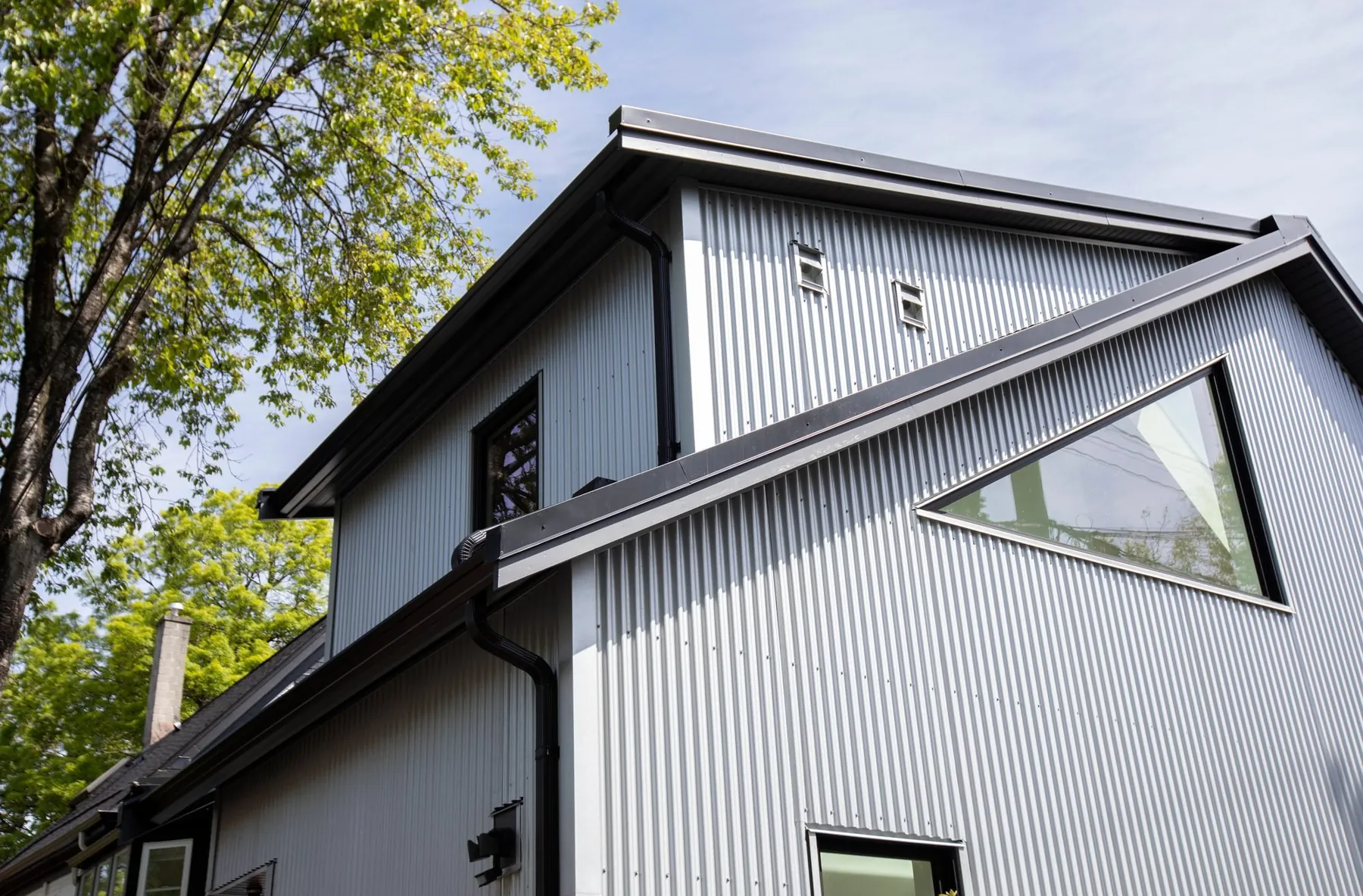 Two-storey laneway home with corrugated metal siding by Smallworks
