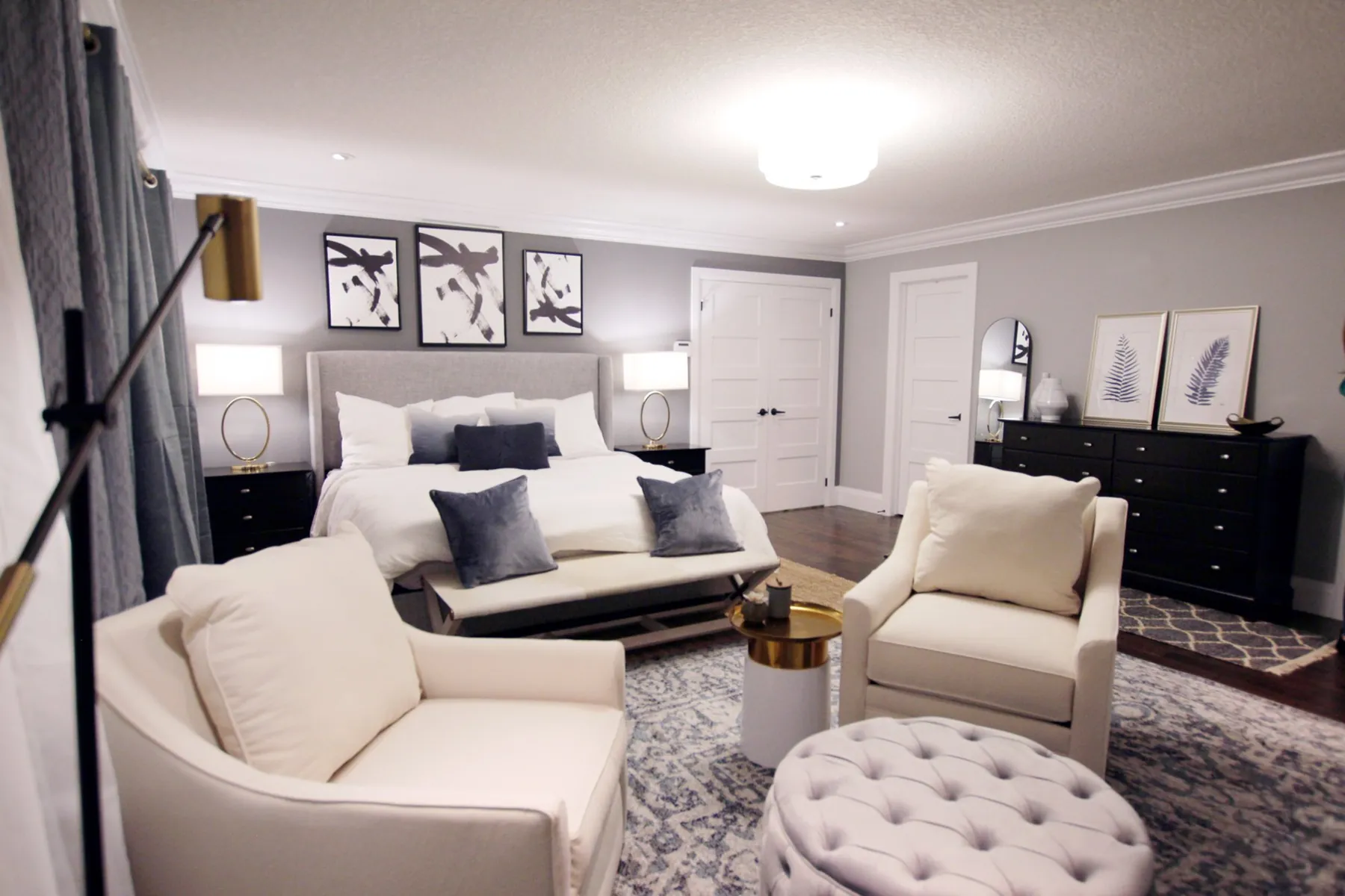 Grey and white bedroom with tufted ottoman by White Dahlia Design