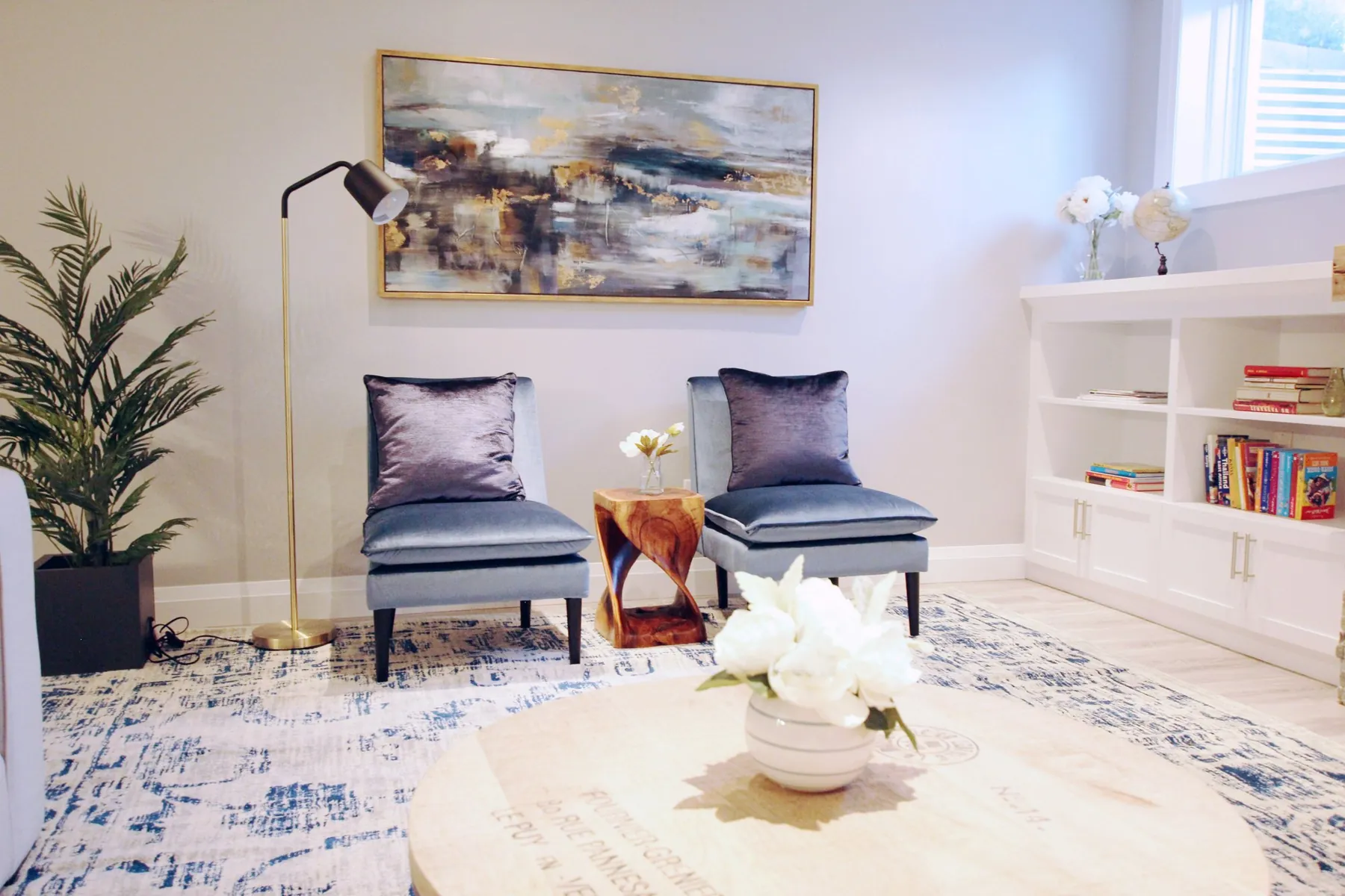 Sitting area with velvet chairs and abstract art by White Dahlia Design