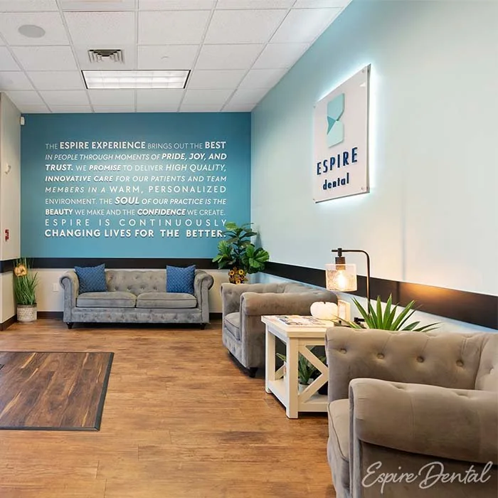 Espire Dental patient lounge with a teal brand wall