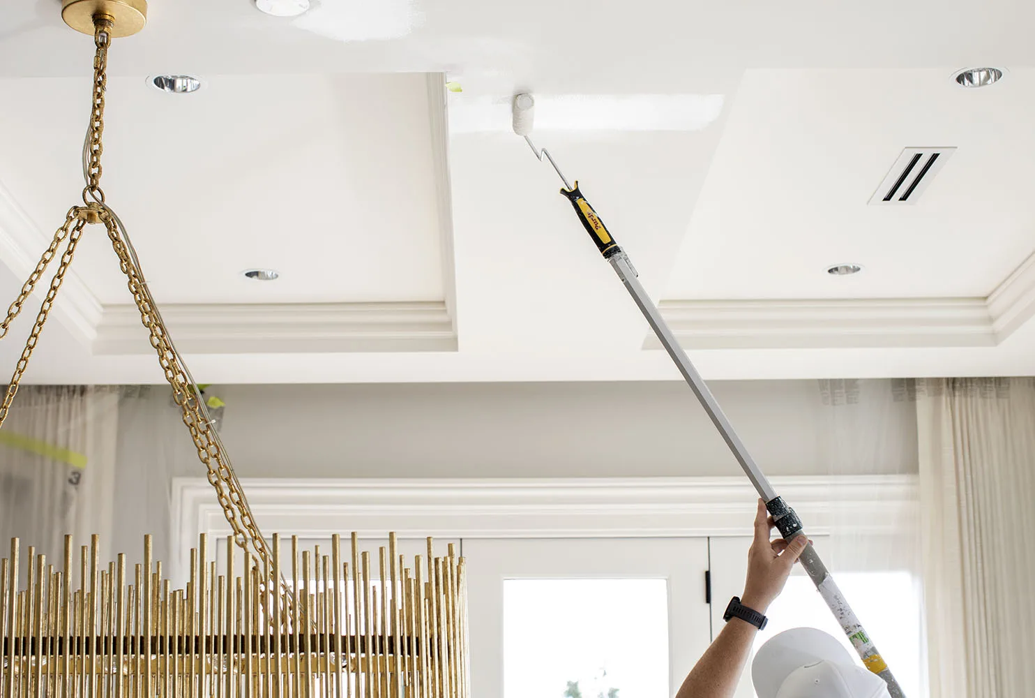 Hemlock Painting painter rolling a white coffered ceiling in a bright Vancouver home