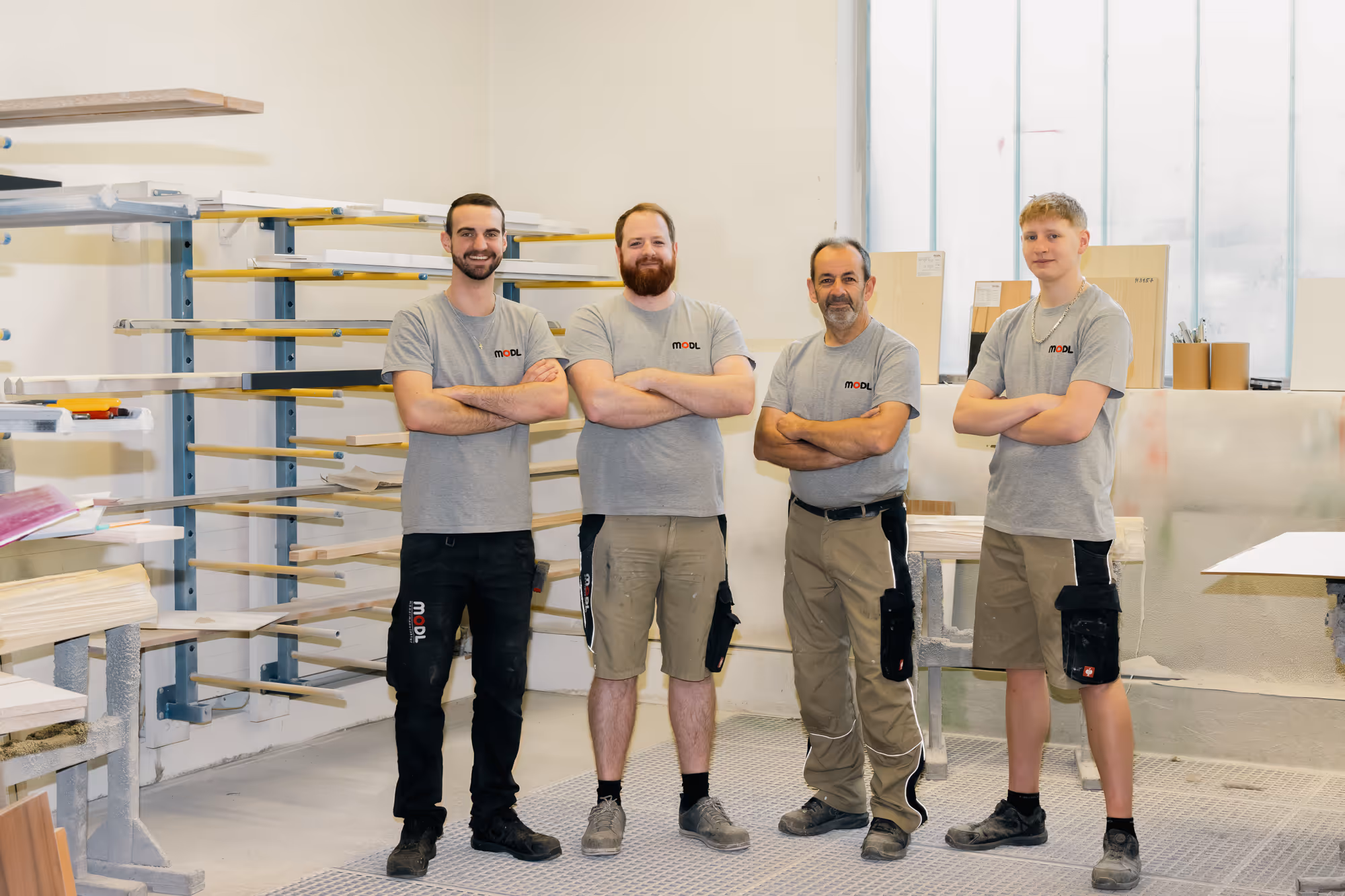 Drei Männer mit Arbeitsoutfit in einer Werkstatt