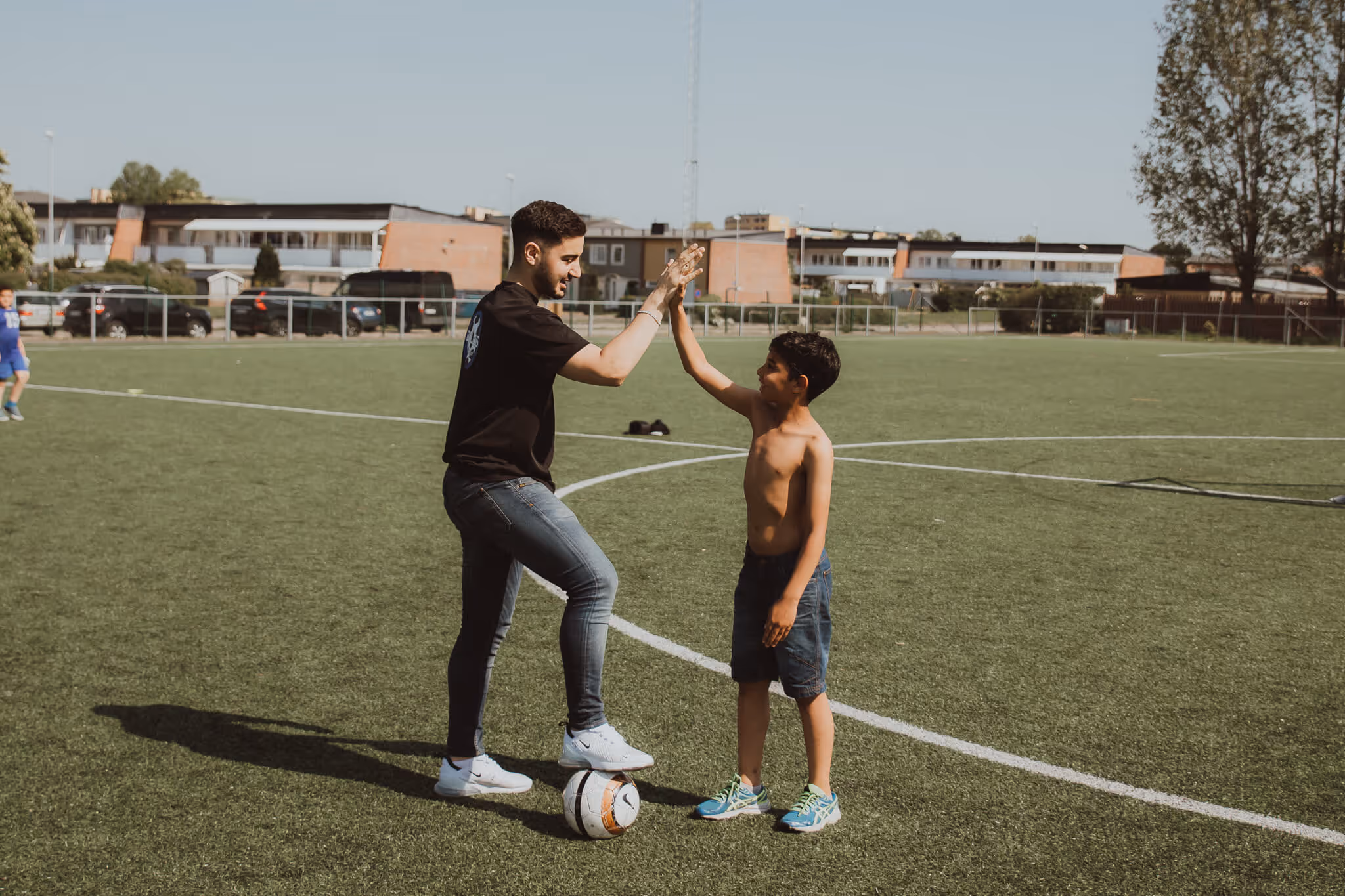 An image depicting a child and coach doing a high-five.