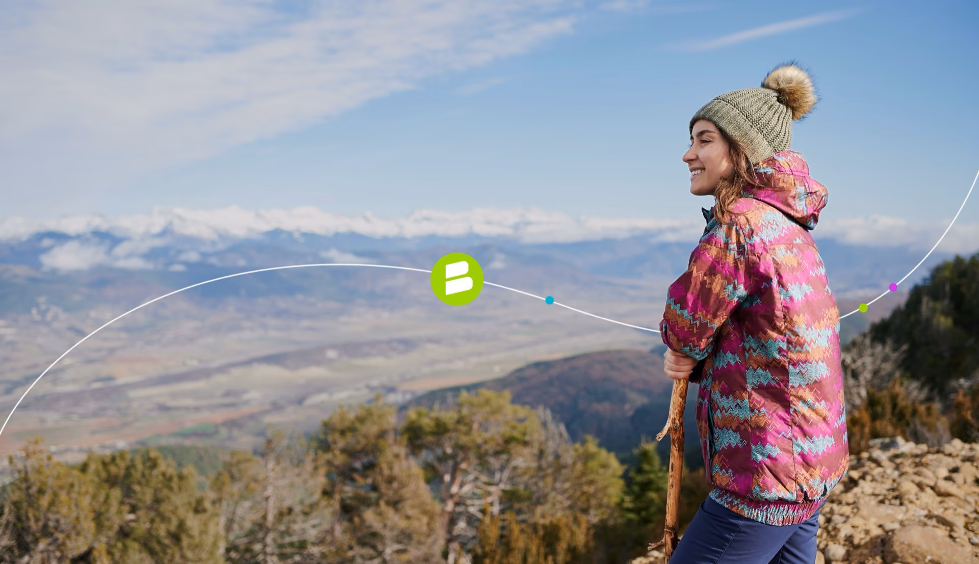 Woman in a winter hat looking out over a mountain valley