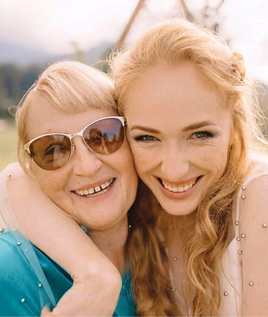 Older woman and younger woman smiling cheek to cheek