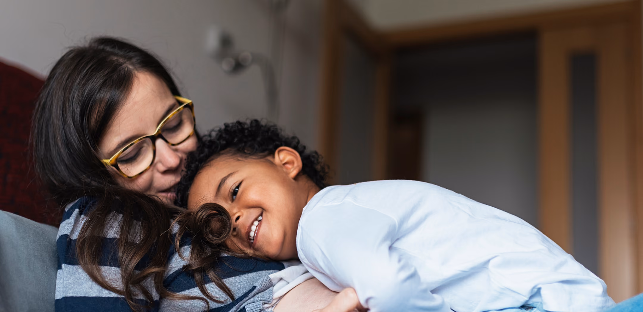 Woman hugging a laughing young child