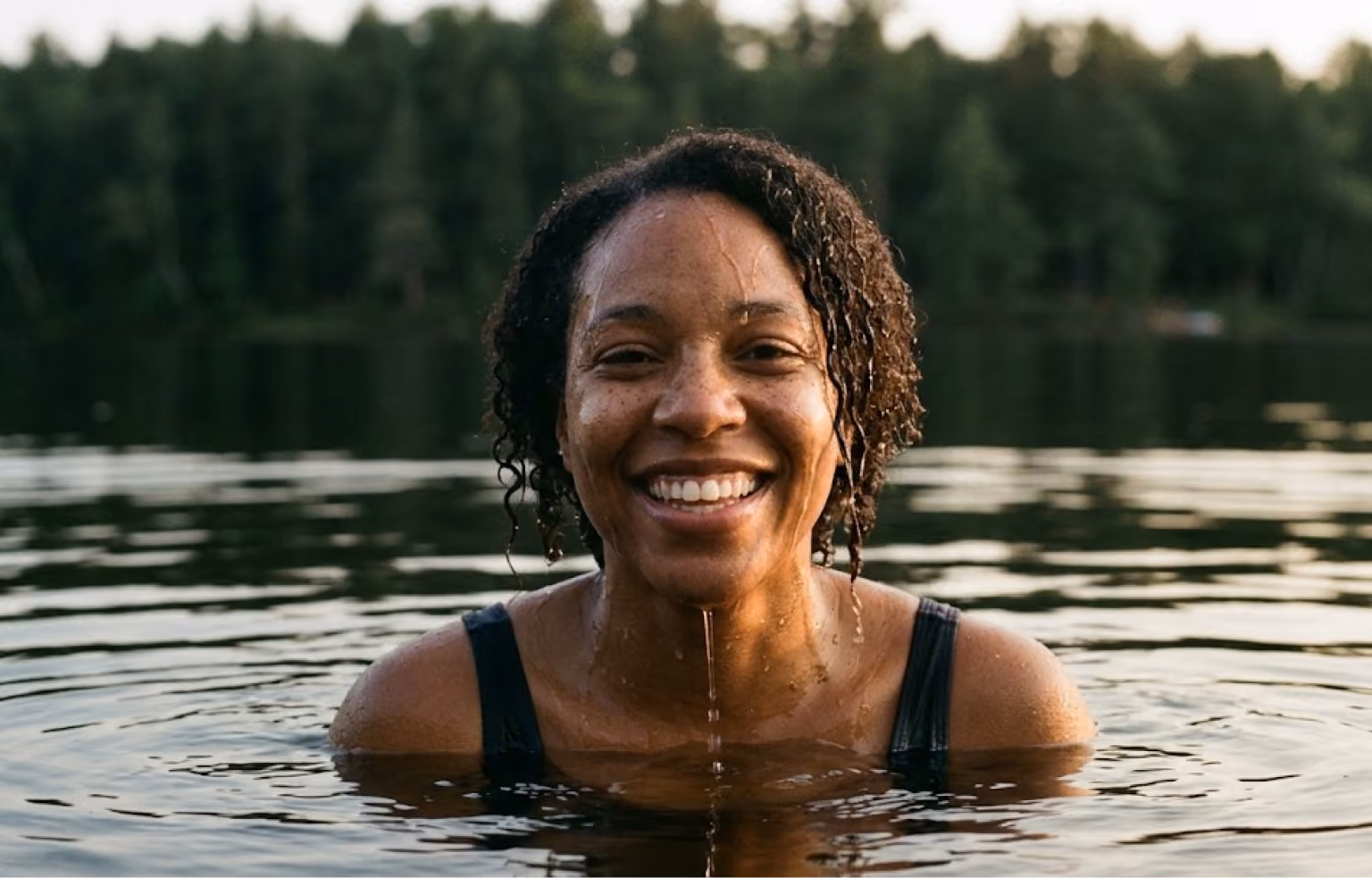 Woman smiling as she swims in a lake