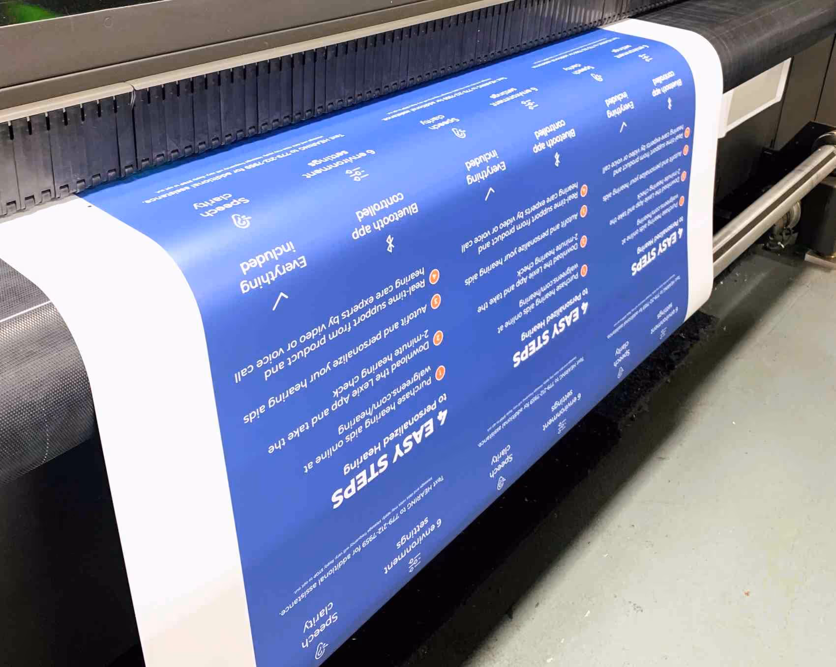 A large format sheet coming off of a roll-to-roll printer