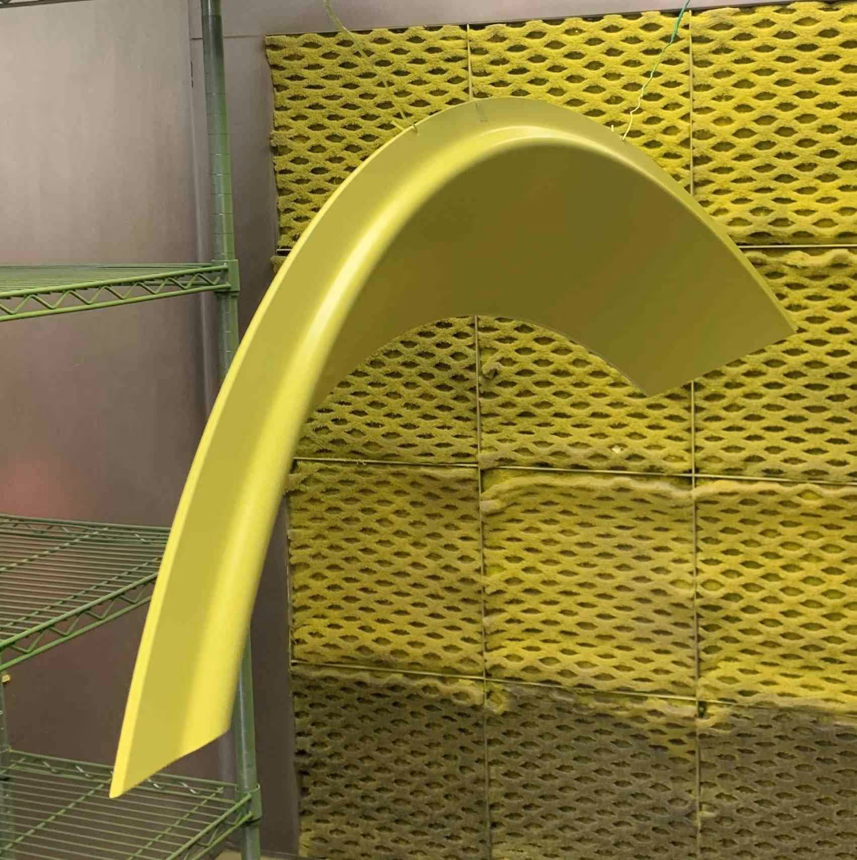 A curved piece of molding drying after being painted.