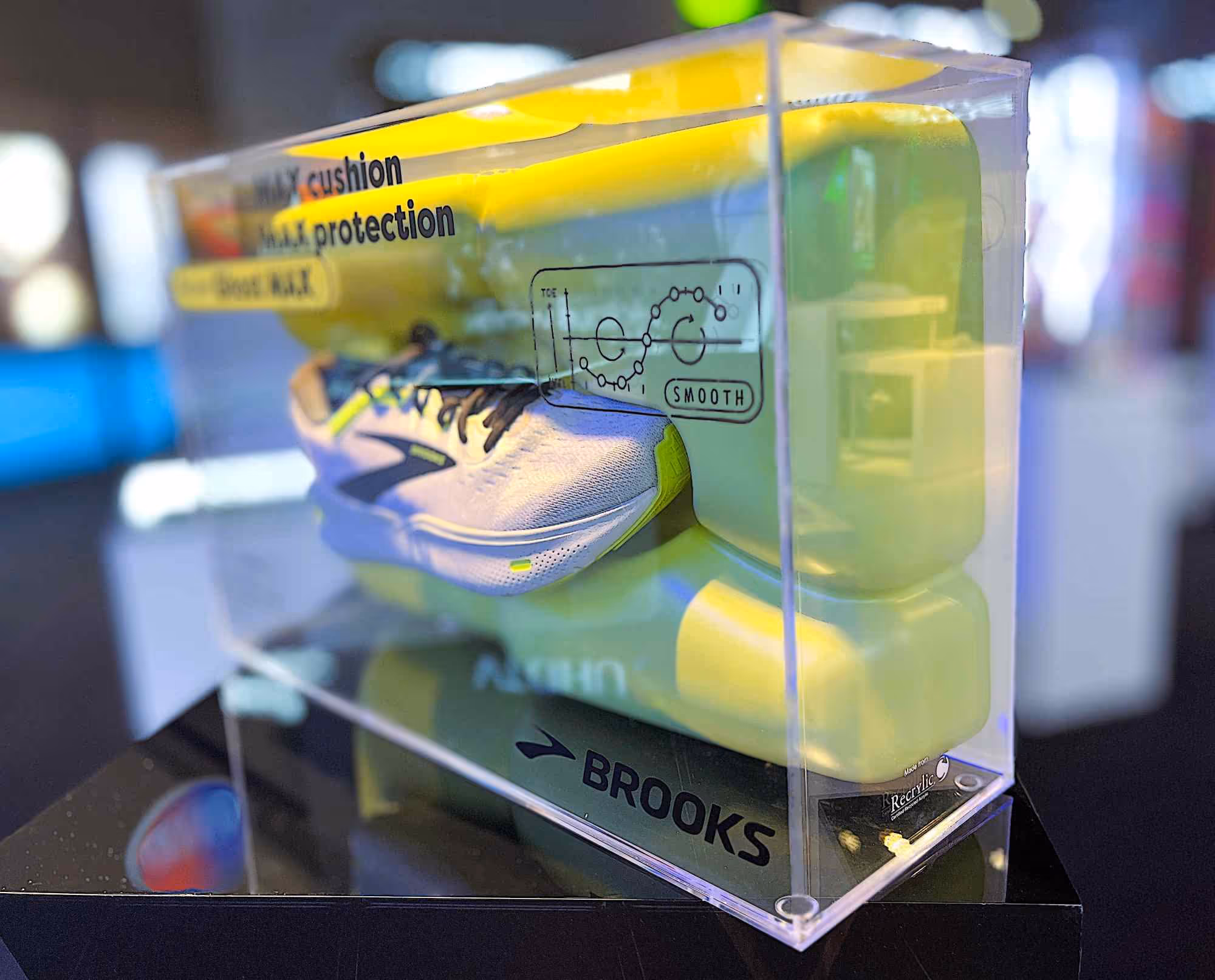 A shoe product fixture made from Recrylic recycled acrylic; clear acrylic box surrounding a thermo-formed green cloud with a shoe displayed