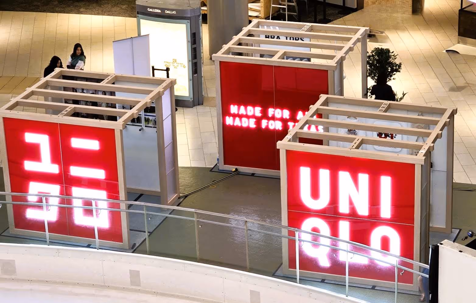 A trio of Uniqlo pop-up retail displays inside a shopping mall.