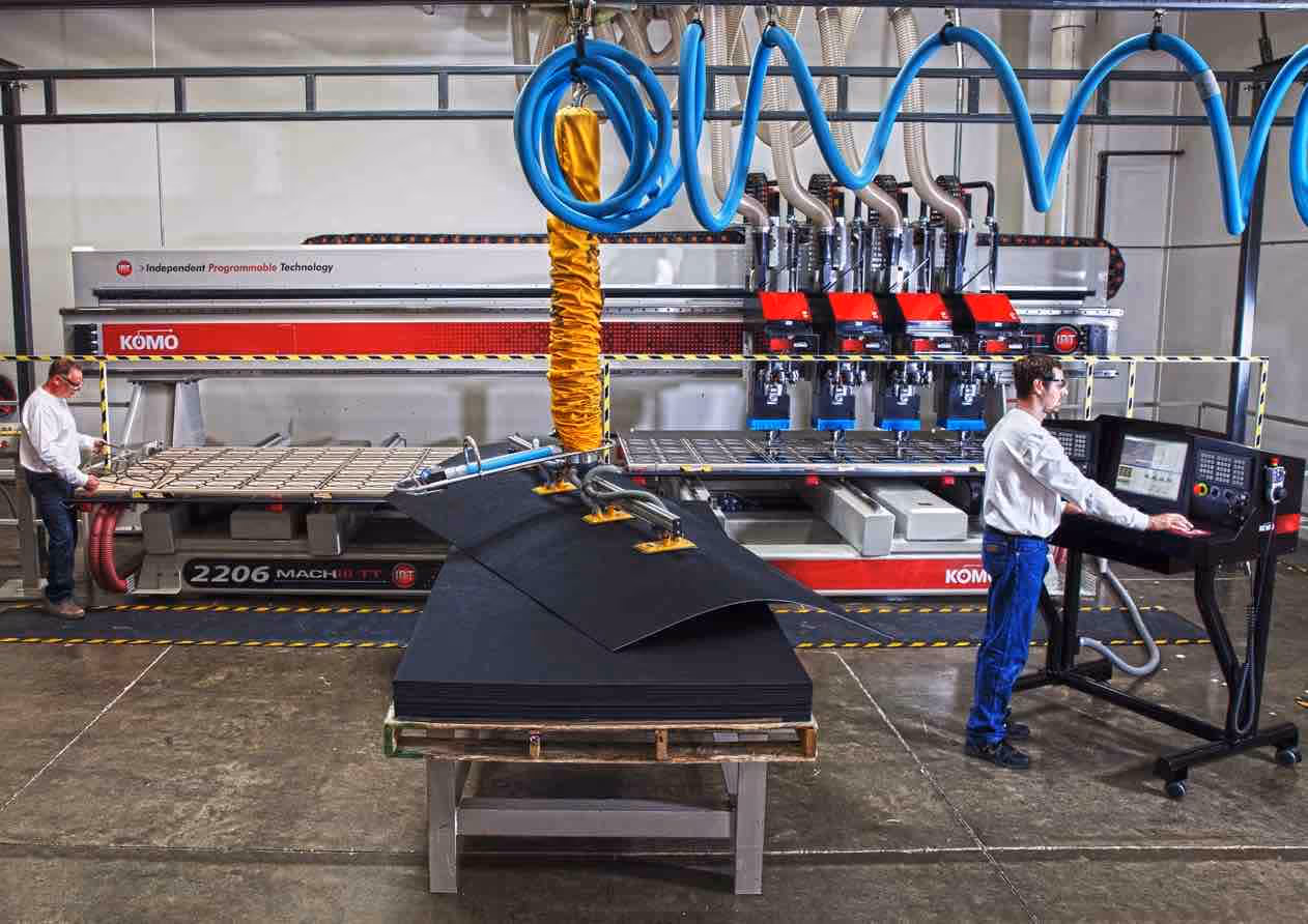 Workers at a CNC machine working on custom acrylic retail displays