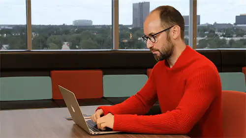EP+Co chief strategy officer typing on computer then taking off sweater