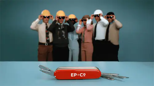 EP+Co branded Swiss Army knife in the foreground. Blurred background shows people wearing hard hats.