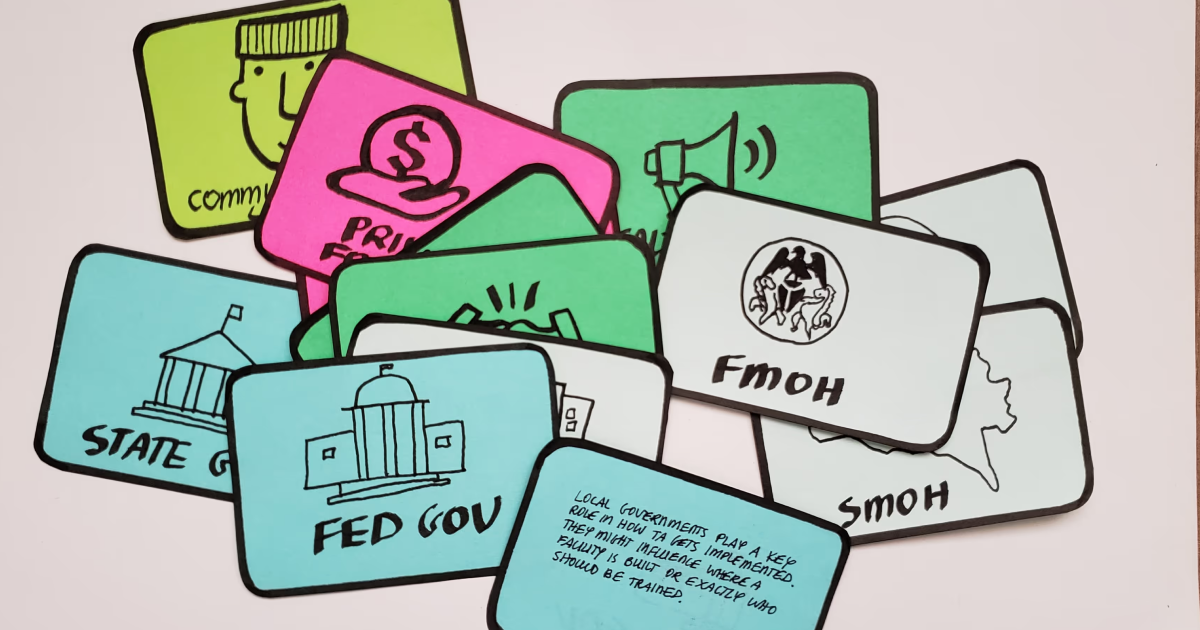 Colorful illustrated cards labeled with government and community terms such as 'FED GOV', 'STATE GOV', 'FMOH', and a card with text about local governments' role in TA implementation.