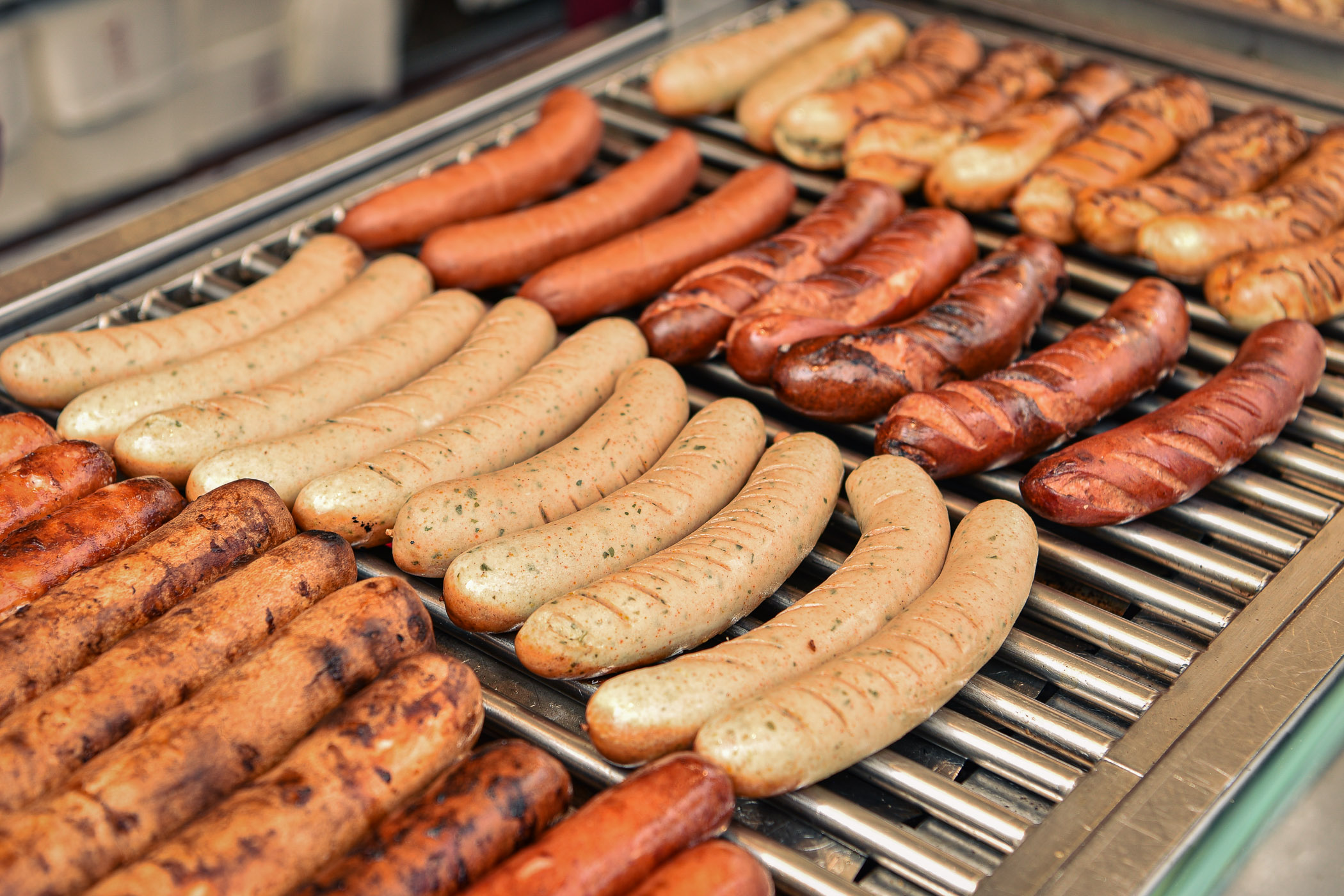 Frische Bratwürste und Rostbratwürste auf dem Grill.