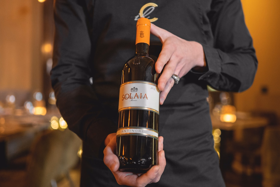 Kellner präsentiert eine Flasche Rotwein