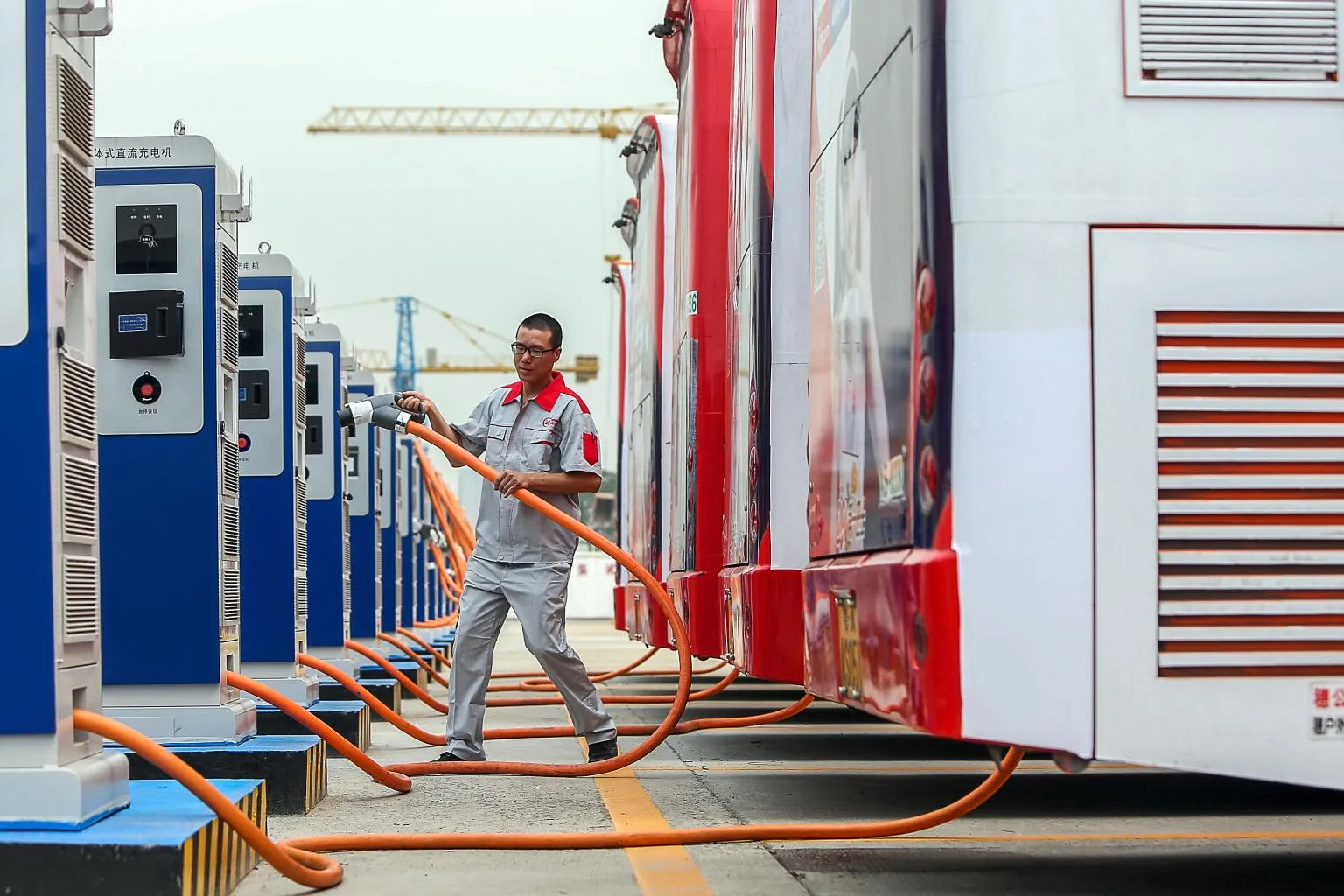 A worker recharges an electric bus at a bus charging station in Guangzhou, China. (Photo: Imaginechina