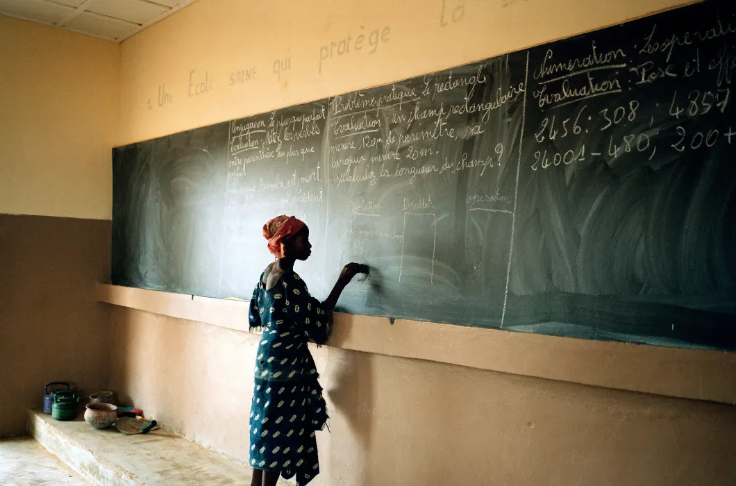 African girl writing on chalkboard