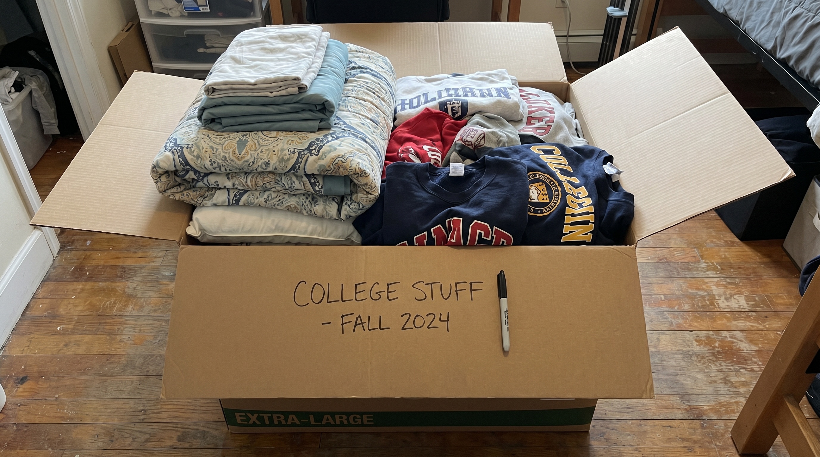 extra large moving box filled with college bedding and clothes