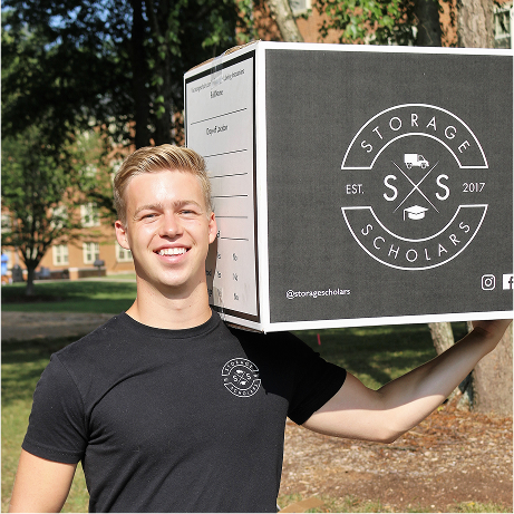 Storage Scholars team member carrying a labeled storage box