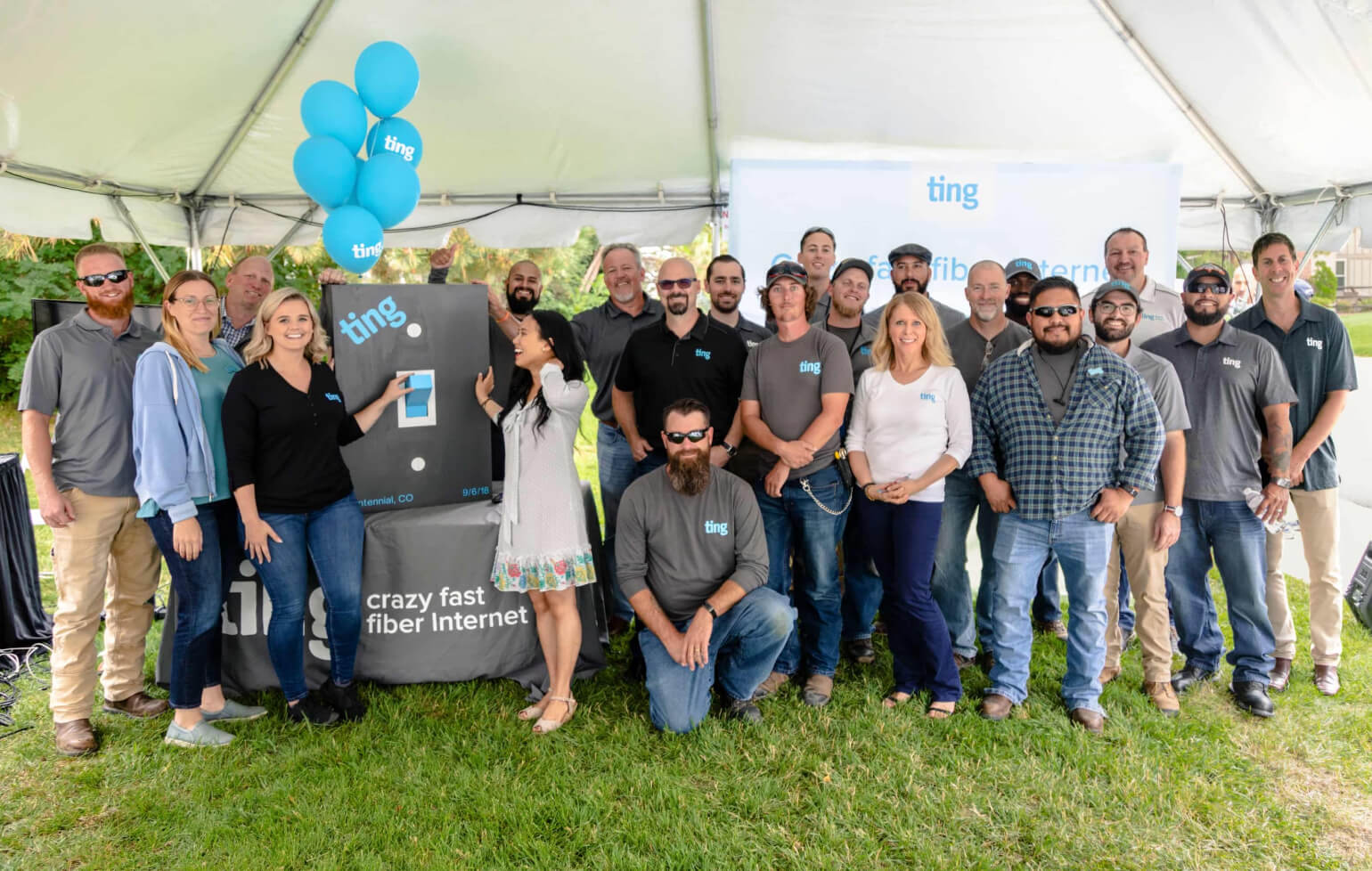 A Ting community event, with a group of people standing beside a giant Ting light switch