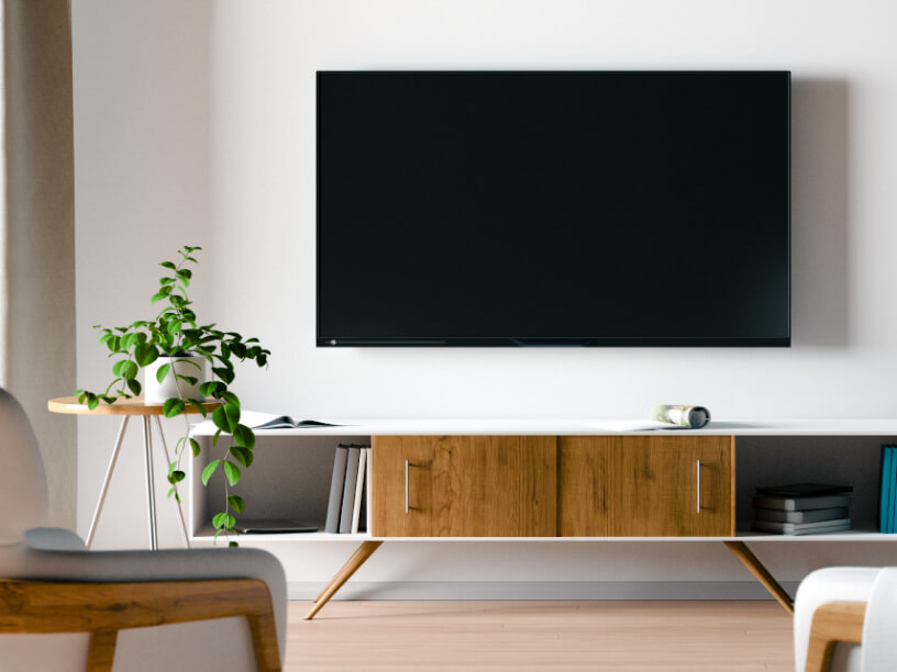 A modern living room with focus on a wall-mounted TV.