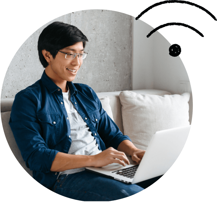 A young person on the couch, using their laptop