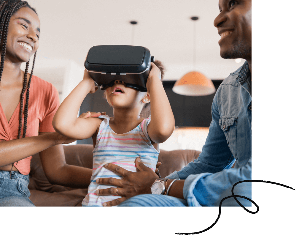A family of three on the couch, the small child with a VR headset on