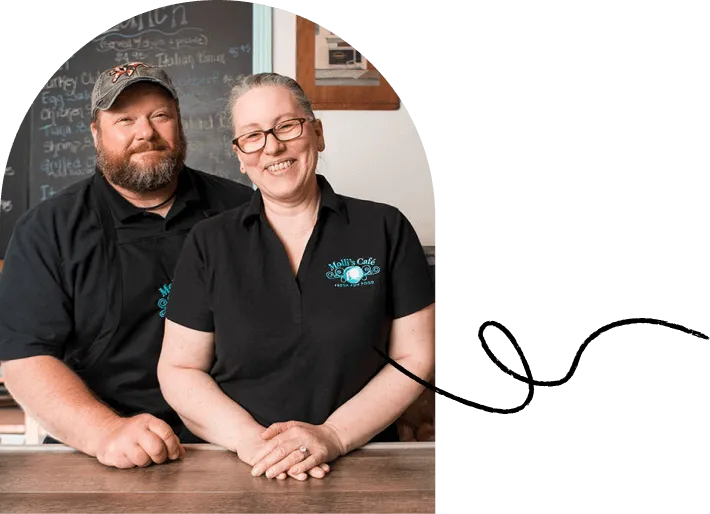 Small business owners standing behind the counter of their cafe.