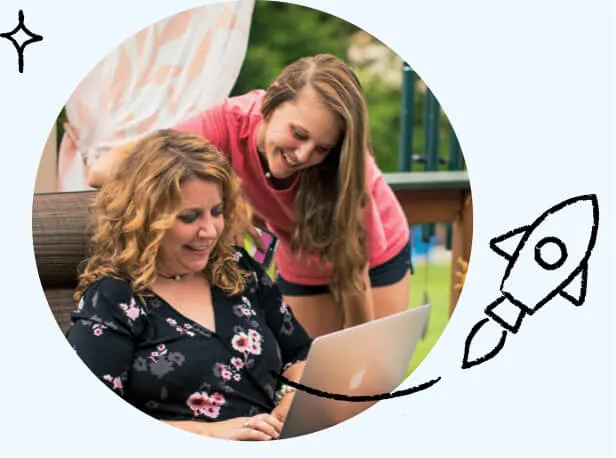 Two family members using the internet on a laptop while lounging outside.