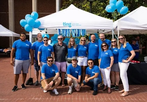 The Ting Internet team, all wearing blue Ting shirts, gathered at a community event.