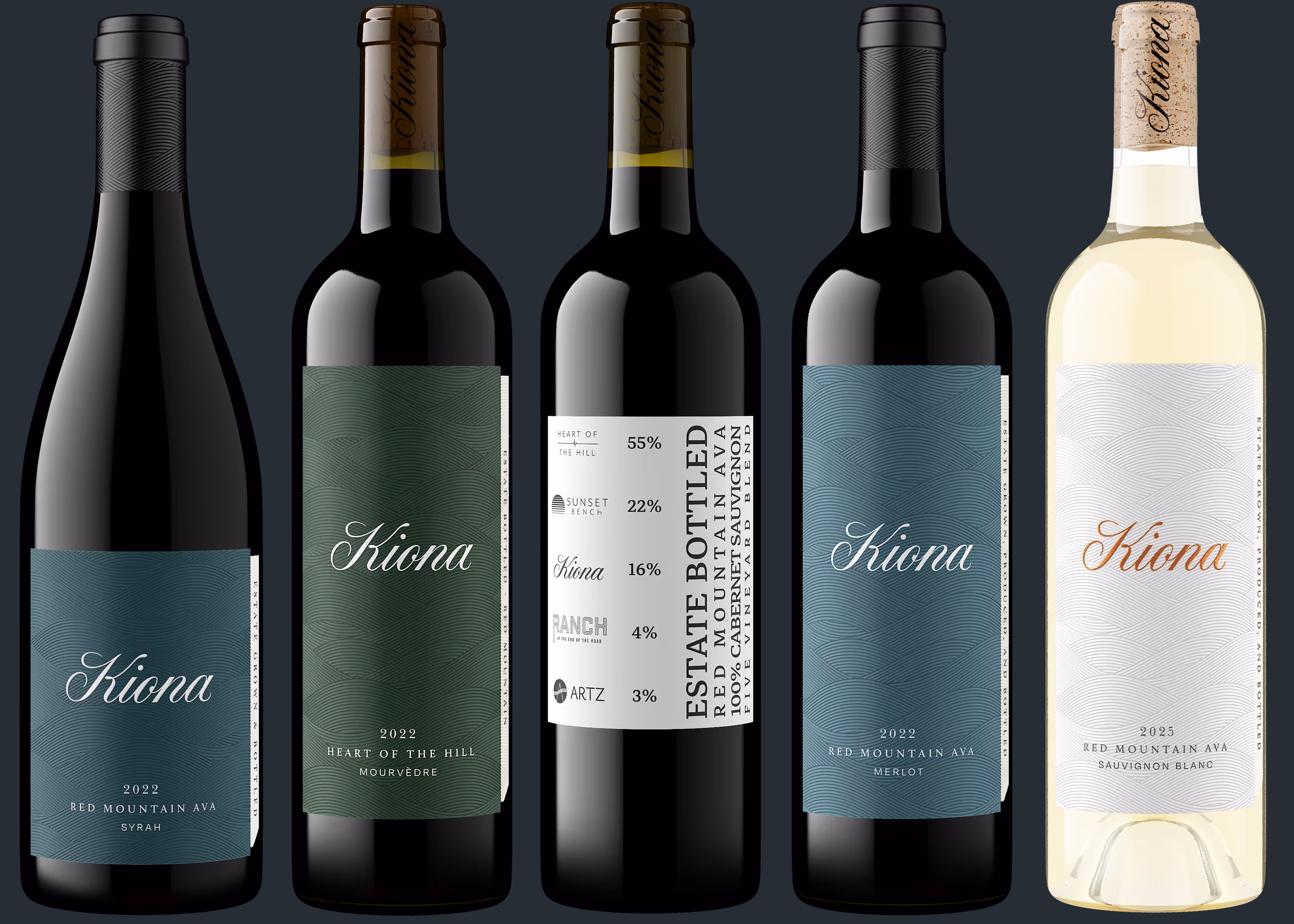 Five Kiona wine bottles: Syrah, Mourvèdre, blend label, Merlot, and Sauvignon Blanc vintages.