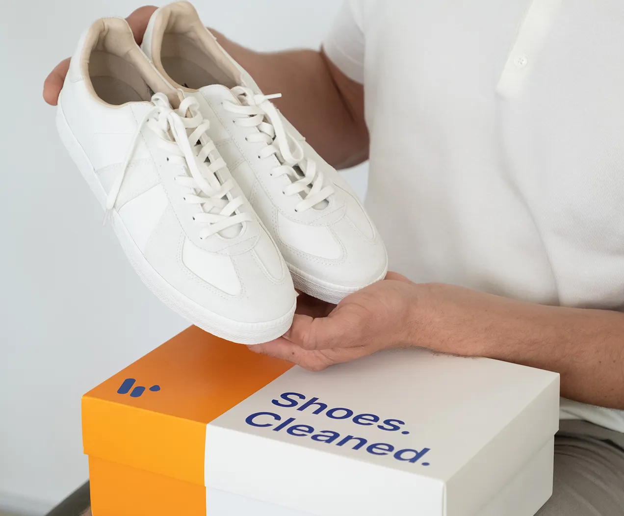 a person holding a pair of white shoes