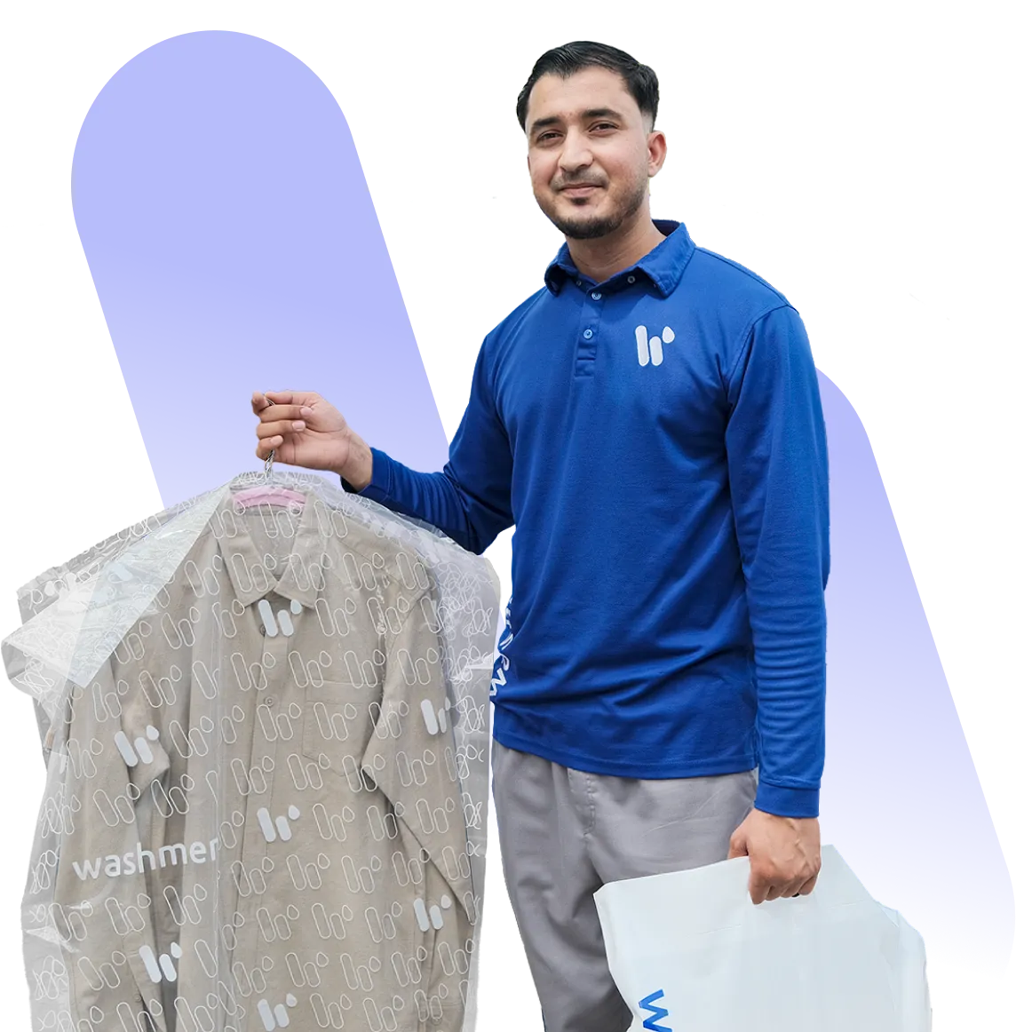 A man wearing a blue polo shirt holds a suit covered in plastic garment bag. He stands in front of a purple background, displaying a friendly demeanor while holding a white bag labeled "washer".