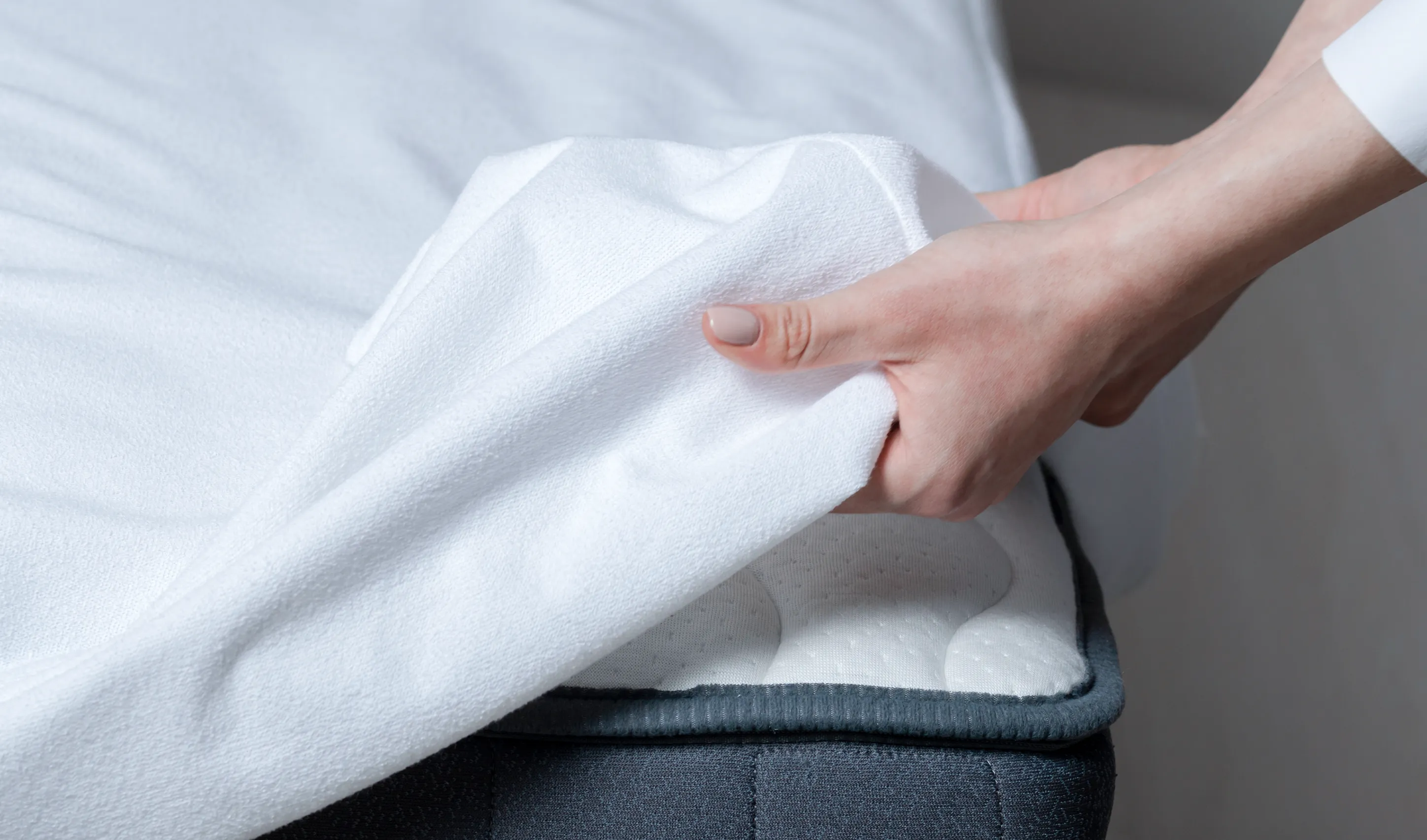 a person's hand holding a white blanket