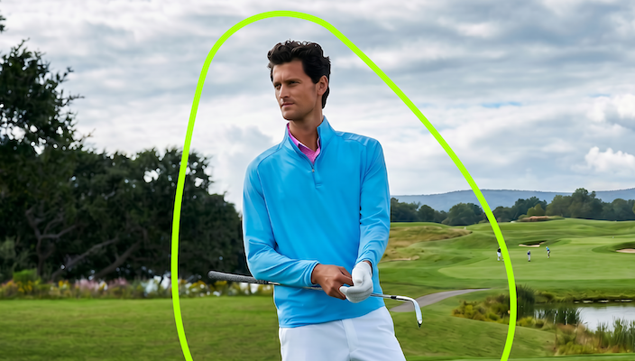  Golfer wearing a light blue quarter-zip polo and white trousers on a golf course